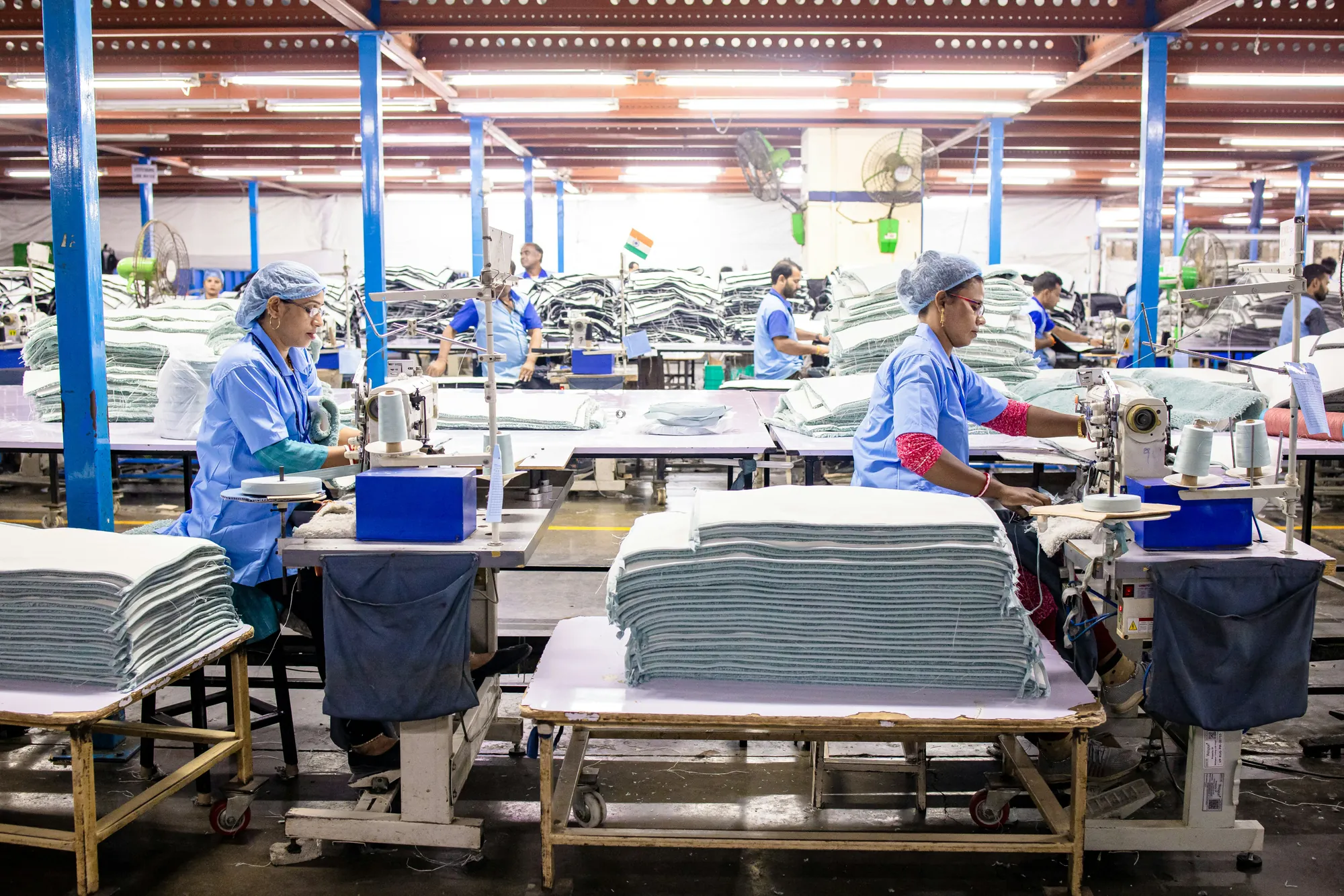 A sewing module in line, operators at their machines with cut work stacked between them