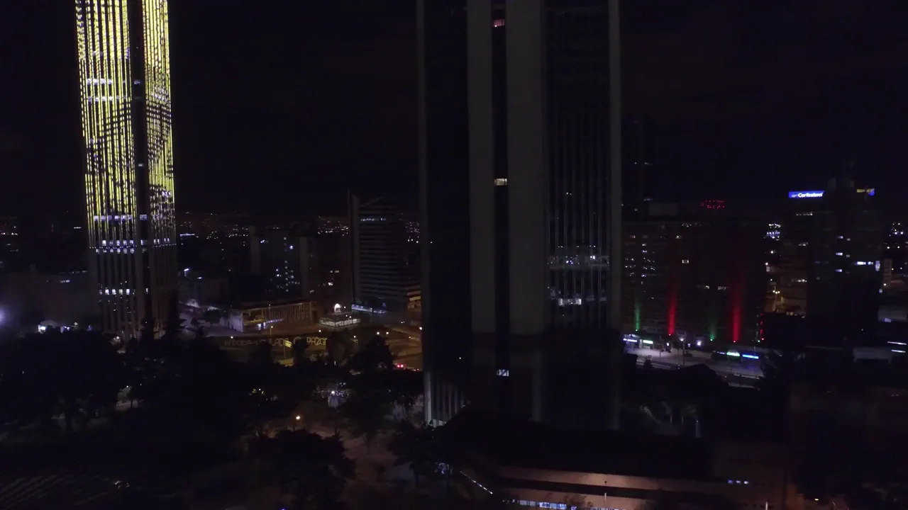 Bogotá at night from the air, a lit tower downtown and the city running out to the hills